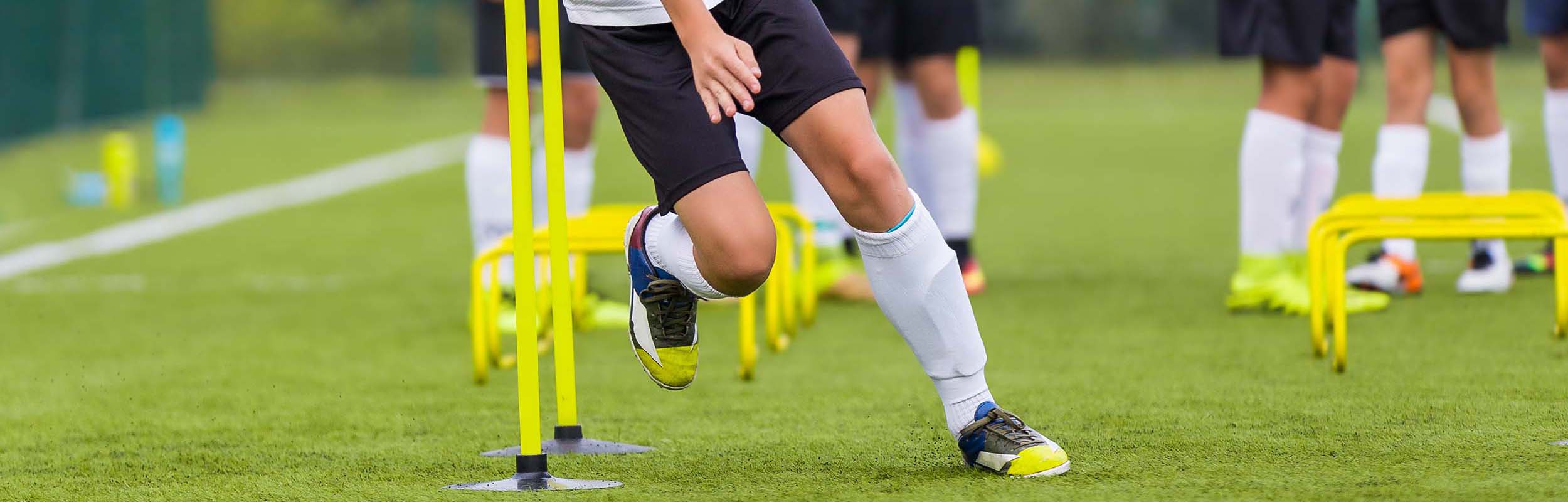 Boy Soccer Player In Training. Boy Running Between Cones During