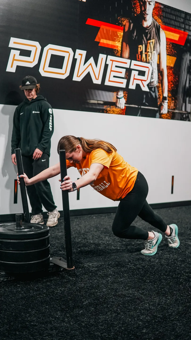 Brynleigh McCracken pushing a weighted sled during a TrueAP training session